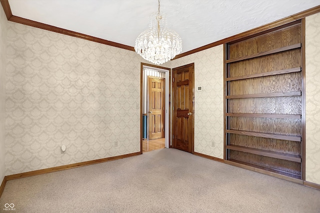 carpeted spare room with crown molding and an inviting chandelier