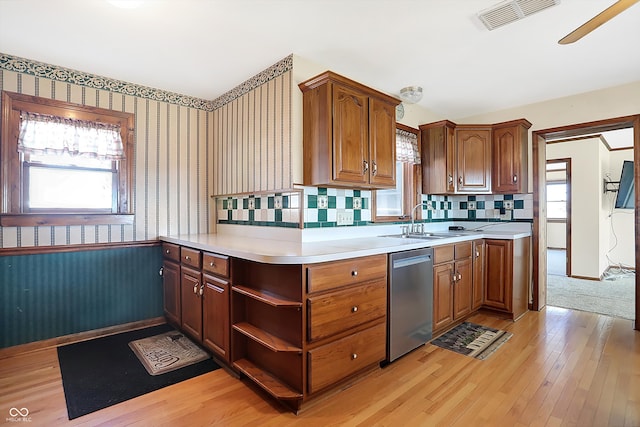 kitchen featuring sink, light hardwood / wood-style flooring, dishwasher, and tasteful backsplash