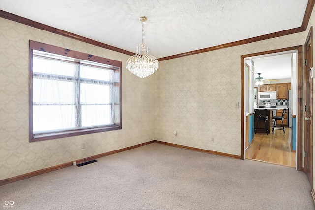 carpeted empty room with ceiling fan with notable chandelier, a textured ceiling, and ornamental molding