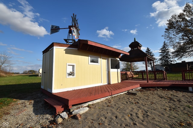 view of side of home with a lawn, a wooden deck, and a gazebo