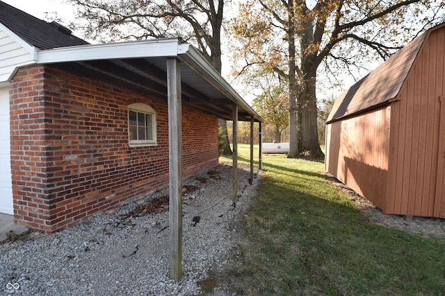 view of property exterior featuring a yard, a carport, and a storage unit