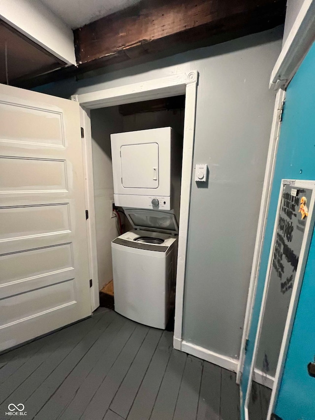 laundry room with stacked washing maching and dryer and dark hardwood / wood-style floors