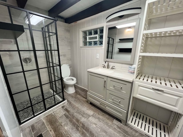 bathroom with toilet, beamed ceiling, hardwood / wood-style floors, vanity, and walk in shower