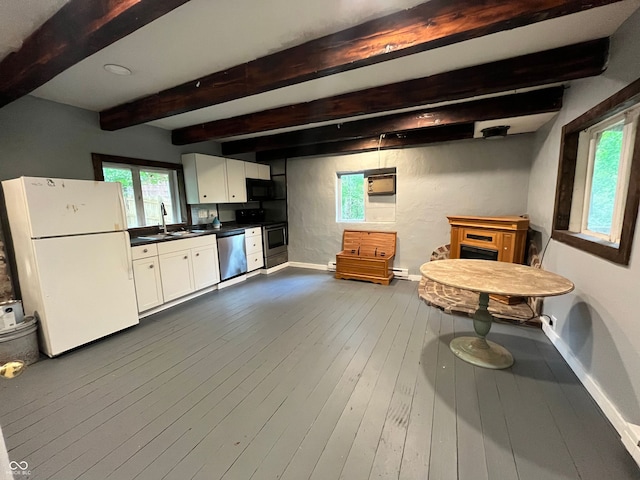 kitchen with appliances with stainless steel finishes, sink, beamed ceiling, white cabinets, and dark hardwood / wood-style floors