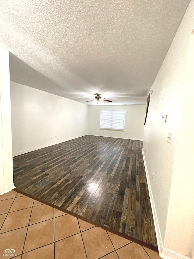 empty room featuring ceiling fan, a textured ceiling, and hardwood / wood-style floors