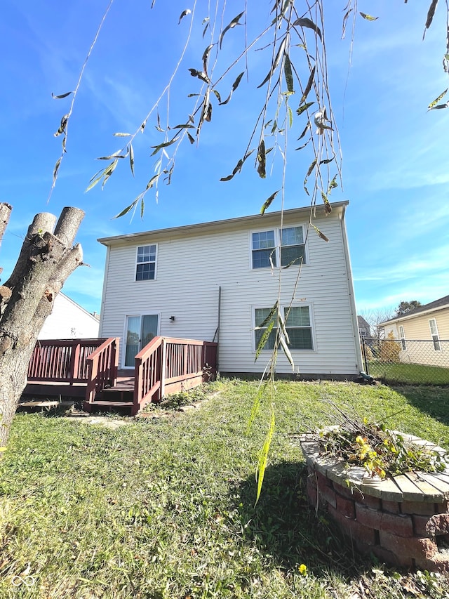 rear view of property featuring a wooden deck and a yard