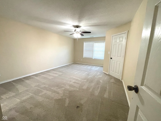 empty room with ceiling fan, carpet, and a textured ceiling