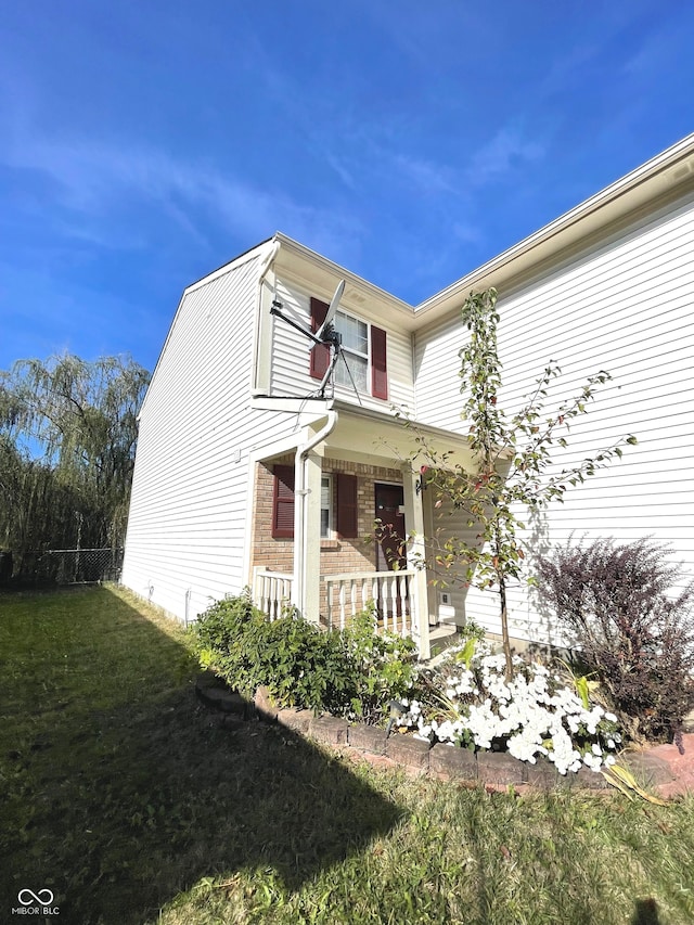 view of side of property with a yard and a porch