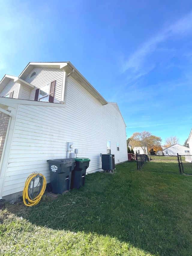 view of property exterior with a yard and central AC unit