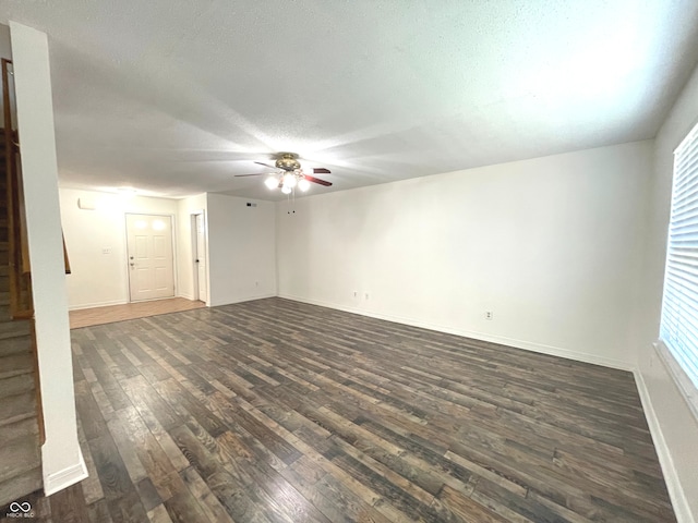 spare room with dark wood-type flooring, ceiling fan, and a textured ceiling