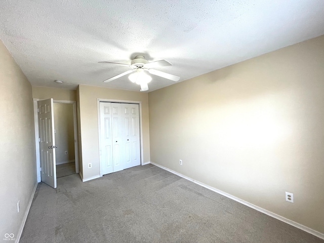 unfurnished bedroom with a closet, ceiling fan, a textured ceiling, and carpet floors