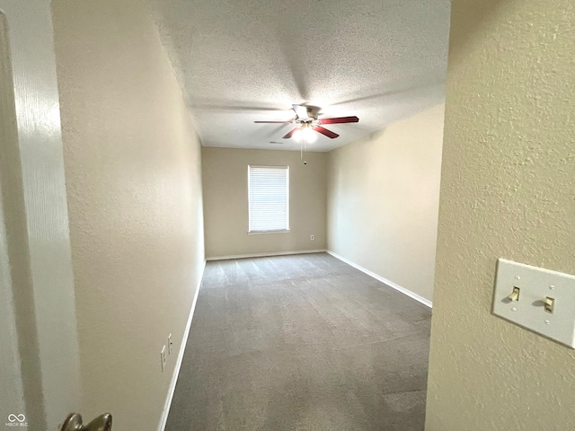 carpeted empty room featuring a textured ceiling and ceiling fan