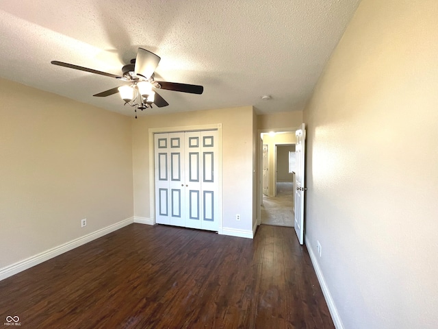 unfurnished bedroom with dark wood-type flooring, ceiling fan, a closet, and a textured ceiling