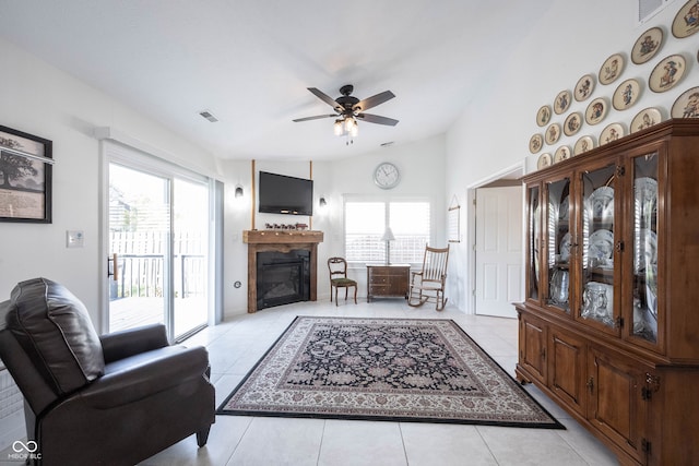 tiled living room featuring lofted ceiling, ceiling fan, and plenty of natural light