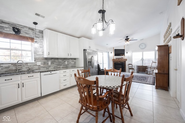 kitchen featuring dishwasher, pendant lighting, vaulted ceiling, and stainless steel fridge