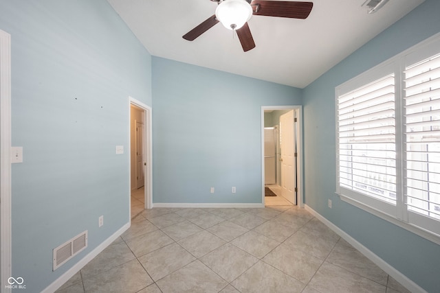 unfurnished bedroom featuring multiple windows, ceiling fan, vaulted ceiling, and light tile patterned flooring