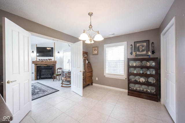 dining area with a chandelier, a textured ceiling, and light tile patterned floors