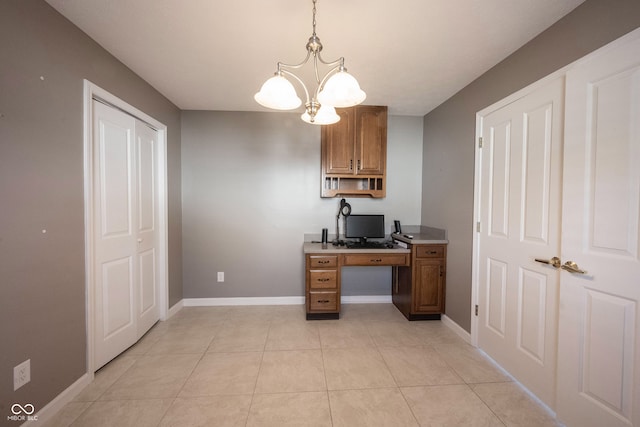 home office with light tile patterned floors and a notable chandelier