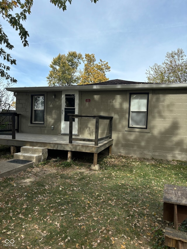 back of property featuring a yard and a deck