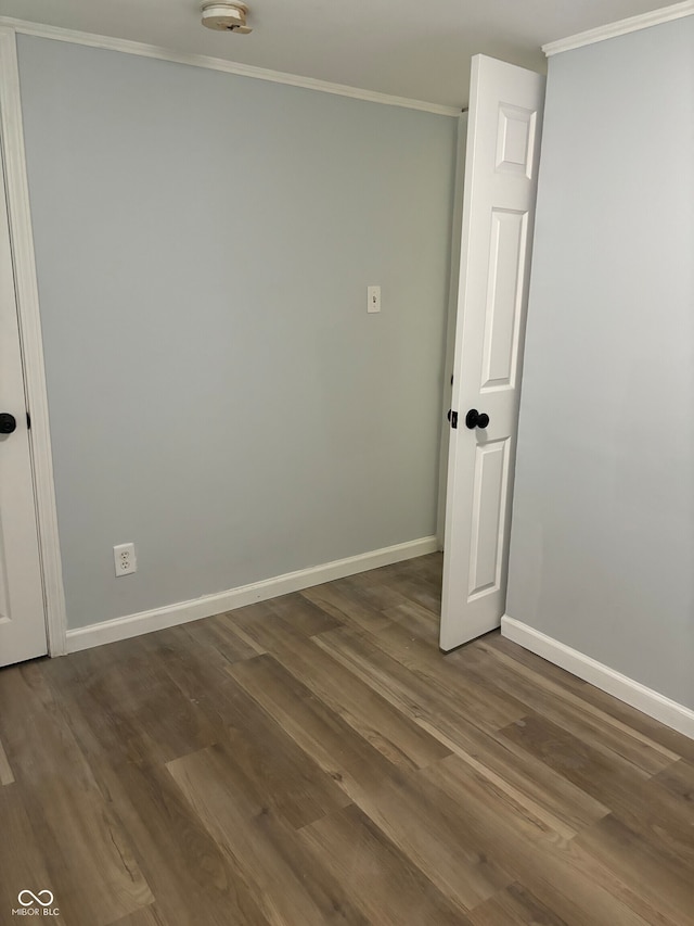 spare room featuring crown molding and dark hardwood / wood-style floors