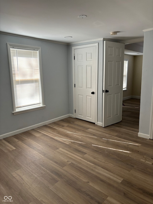 unfurnished bedroom with dark wood-type flooring and multiple windows