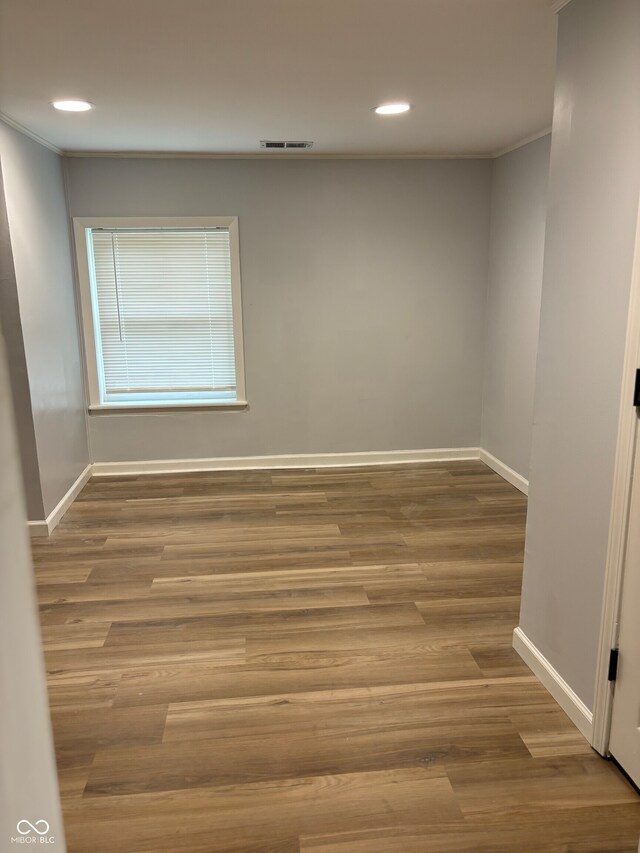 unfurnished room with ornamental molding and hardwood / wood-style flooring