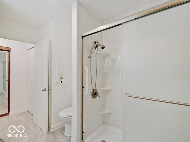 bathroom featuring toilet, an enclosed shower, a textured ceiling, and tile patterned flooring