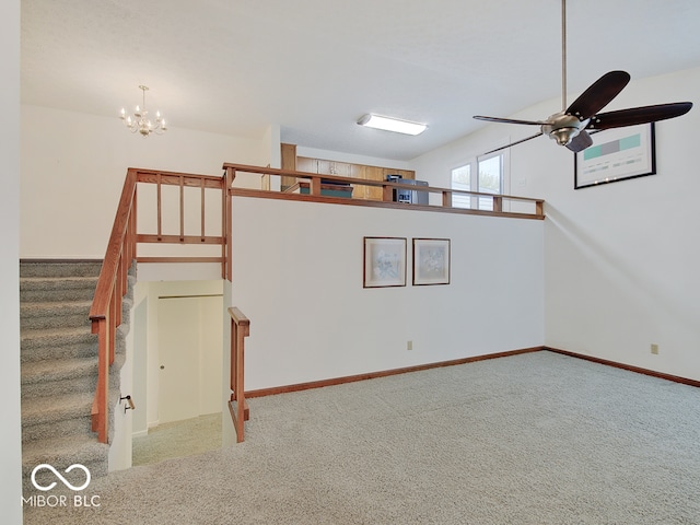 unfurnished living room featuring carpet flooring and ceiling fan with notable chandelier