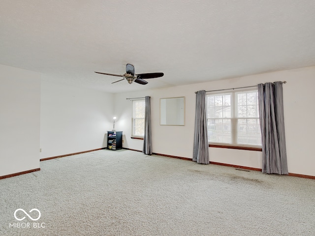 carpeted empty room featuring ceiling fan and a textured ceiling