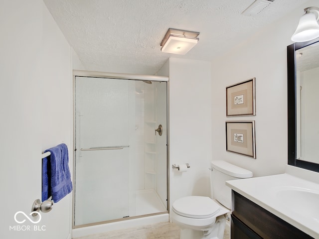 bathroom with walk in shower, vanity, toilet, and a textured ceiling