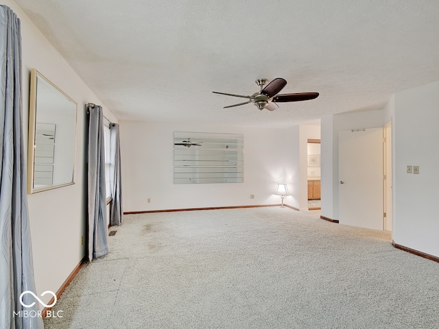 carpeted spare room featuring ceiling fan and a textured ceiling