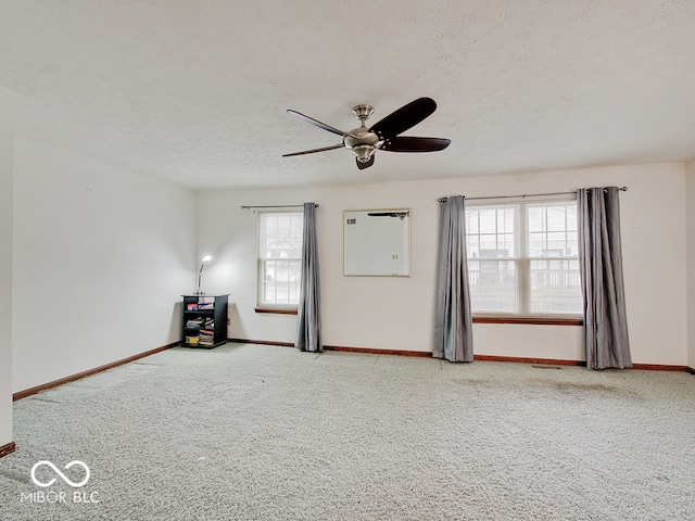 carpeted empty room with a textured ceiling and ceiling fan