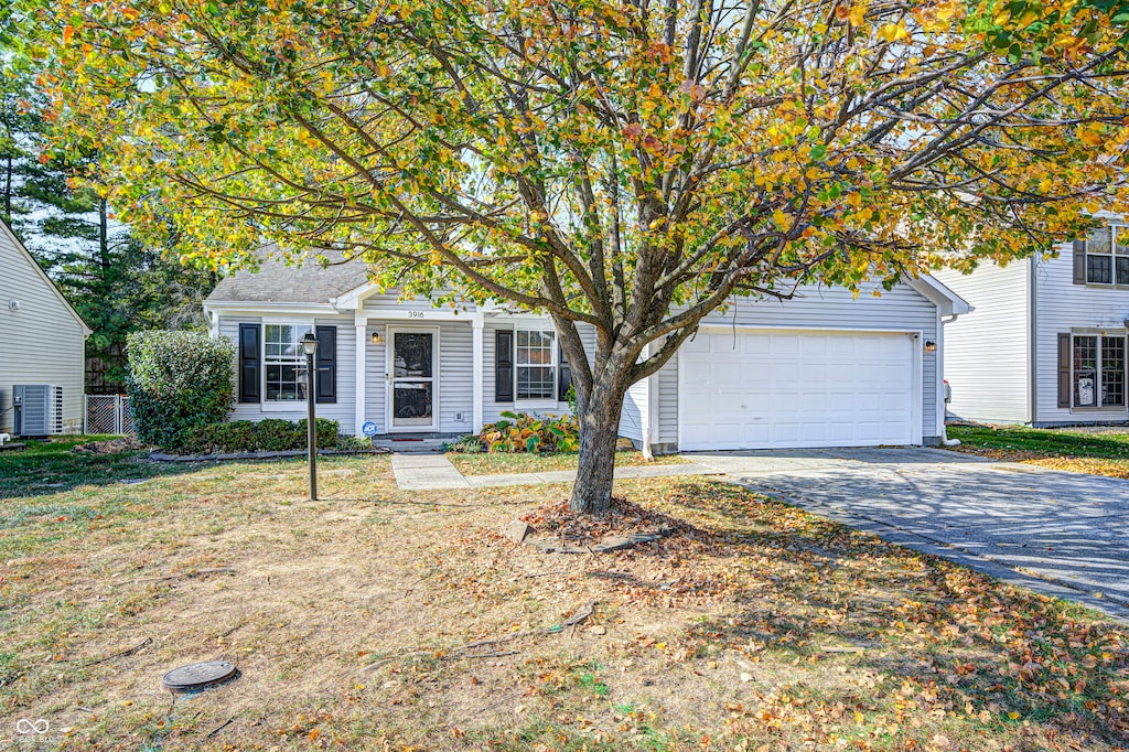 view of front facade with cooling unit, a front lawn, and a garage