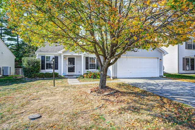 view of front facade with cooling unit, a front lawn, and a garage