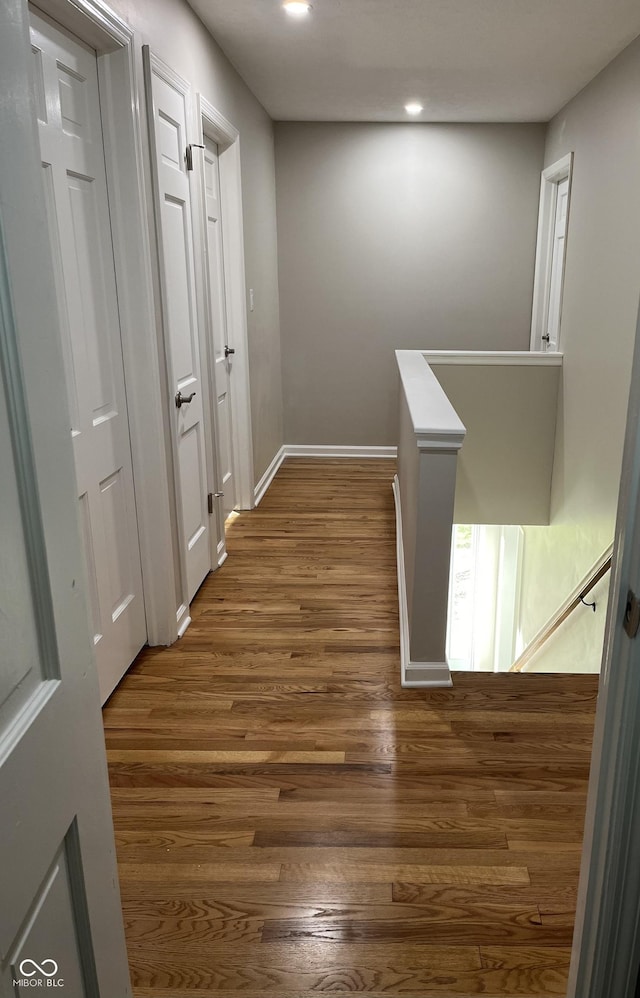 corridor with dark hardwood / wood-style flooring