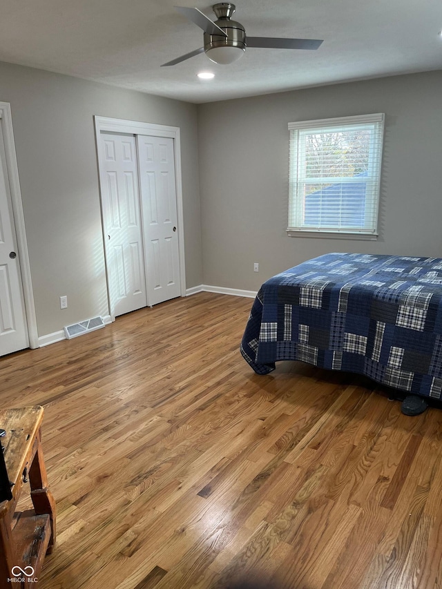 bedroom with ceiling fan, a closet, and hardwood / wood-style flooring