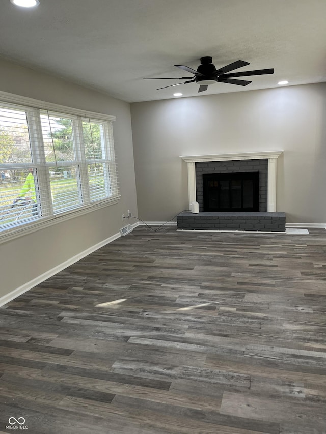 unfurnished living room with ceiling fan, dark hardwood / wood-style flooring, and a fireplace