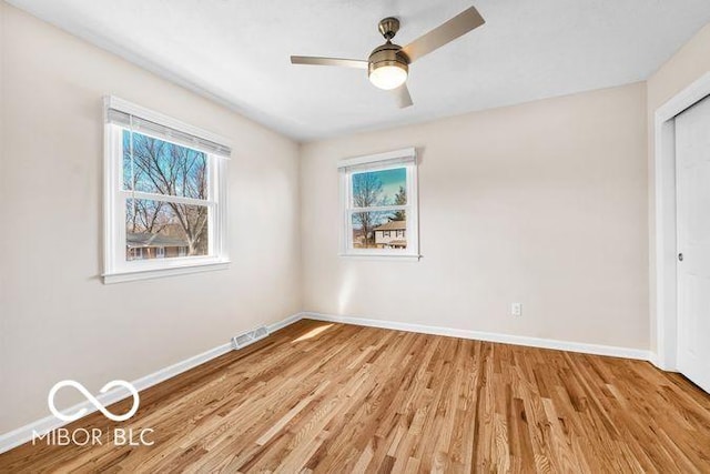 unfurnished bedroom with light wood finished floors, visible vents, baseboards, and a closet