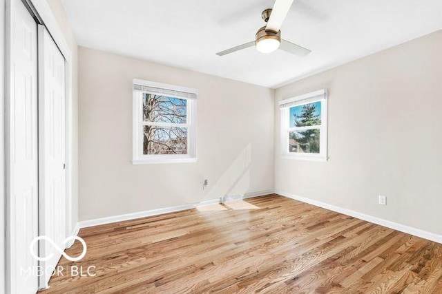 unfurnished bedroom featuring a ceiling fan, a closet, baseboards, and wood finished floors