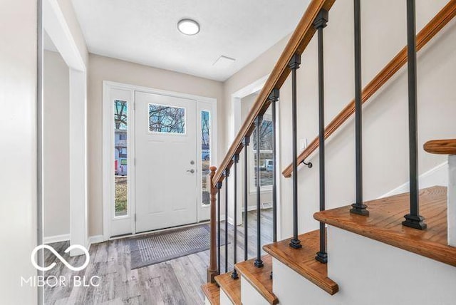 entrance foyer with stairs, baseboards, and wood finished floors