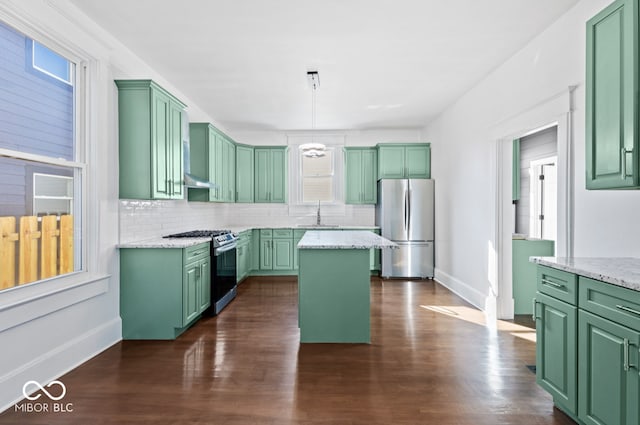 kitchen with a center island, appliances with stainless steel finishes, hanging light fixtures, and green cabinets