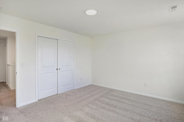 unfurnished bedroom featuring a closet and light carpet