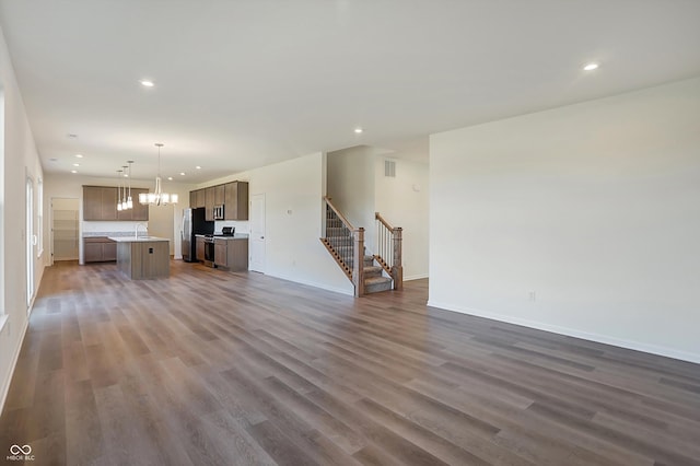 unfurnished living room featuring sink, dark hardwood / wood-style flooring, and a chandelier