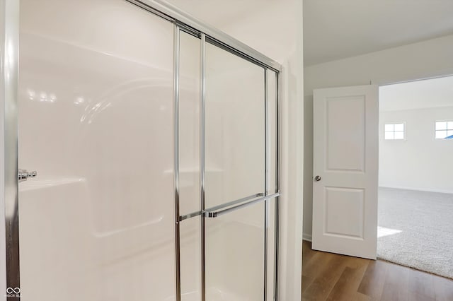 bathroom featuring a shower with door and hardwood / wood-style floors