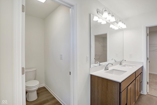 bathroom with toilet, hardwood / wood-style flooring, and vanity