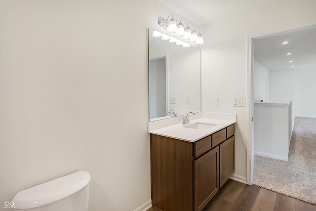 bathroom with vanity, toilet, and hardwood / wood-style flooring