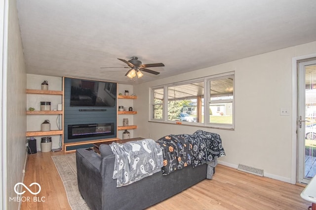 living room with light hardwood / wood-style floors and ceiling fan