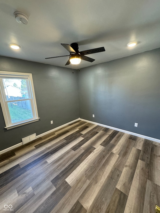 spare room with ceiling fan and dark wood-type flooring