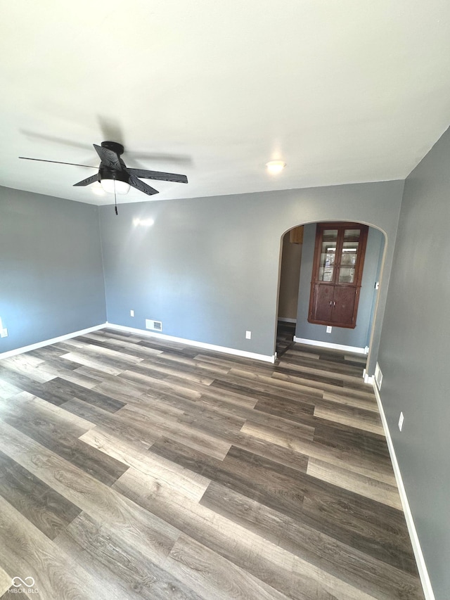 empty room featuring ceiling fan and dark hardwood / wood-style flooring