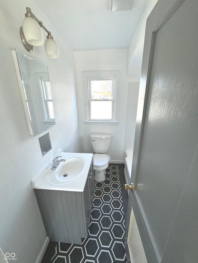 bathroom with walk in shower, tile patterned flooring, vanity, and toilet